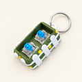 Grasveld clicker base met sleutelhanger op een lichte achtergrond