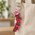 Rode panda sleutelhanger aan een beige tas